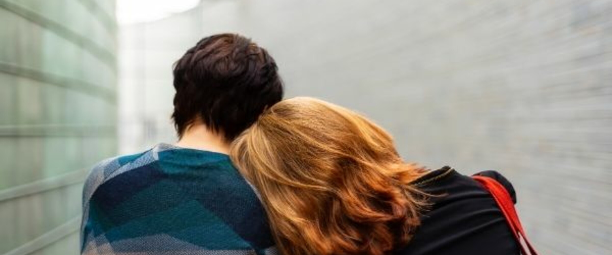 A woman rests her head on her partner's shoulder
